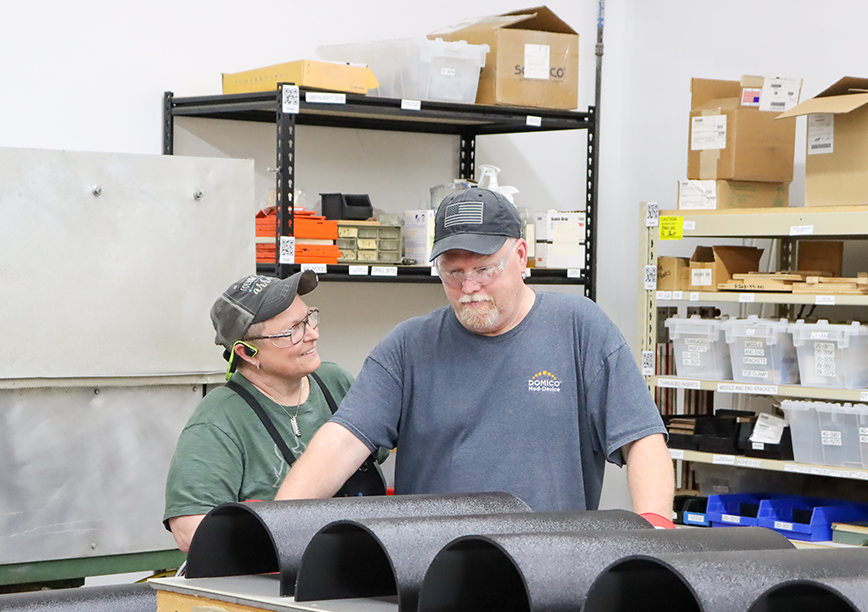 A man and woman working together to assemble medical devices.