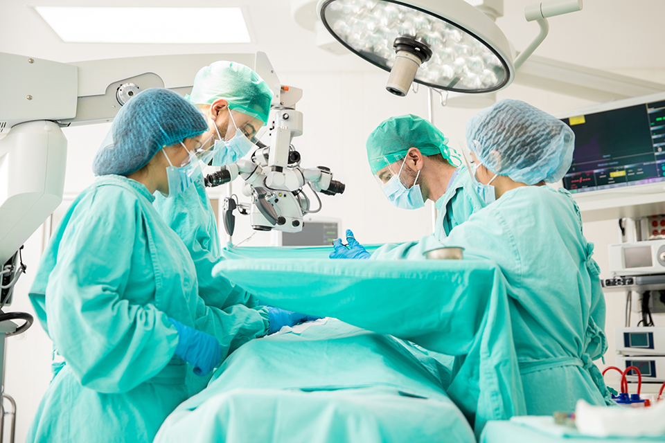 A photo of doctors gathered around a patient during surgery.