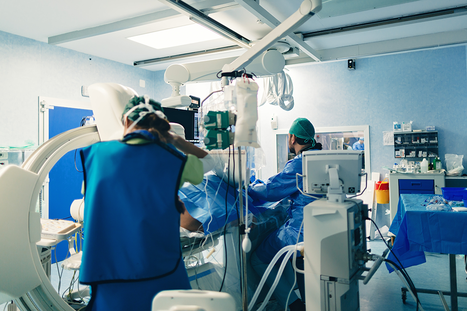 An interventional cardiologist using an angiography system on a patient.