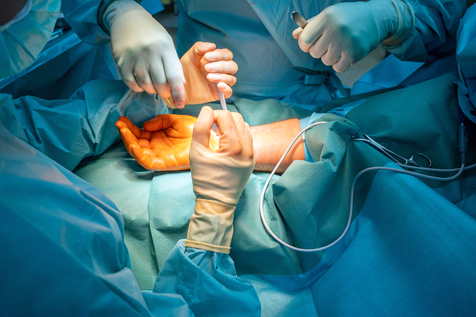 A photo of surgery being performed on a hand.