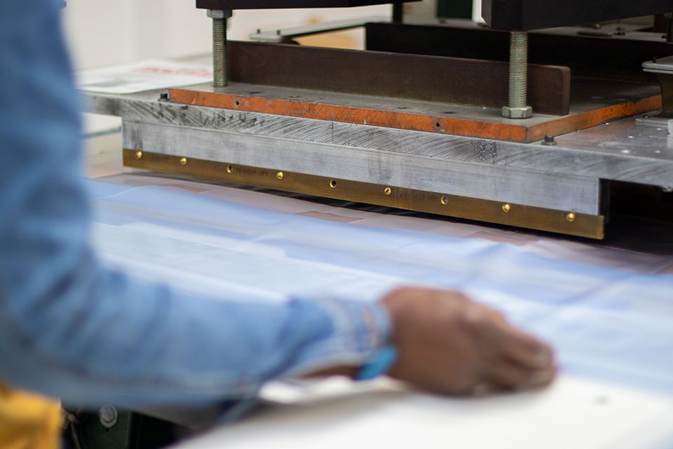 A photo of a person working at a heat seal machine.