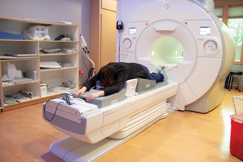 A woman laying on patient positioning devices as she gets an MRI completed 
