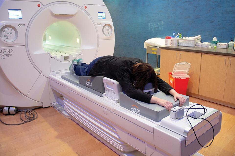 A woman getting an MRI done laying on a patient positioning system