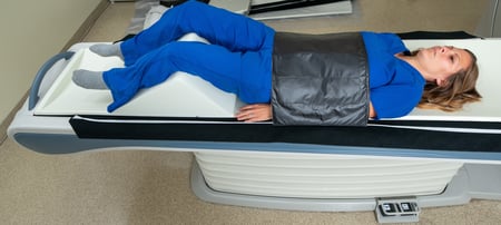 A photo of a woman strapped to a Canon Aquilion CT machine with Domico Med-Device straps.