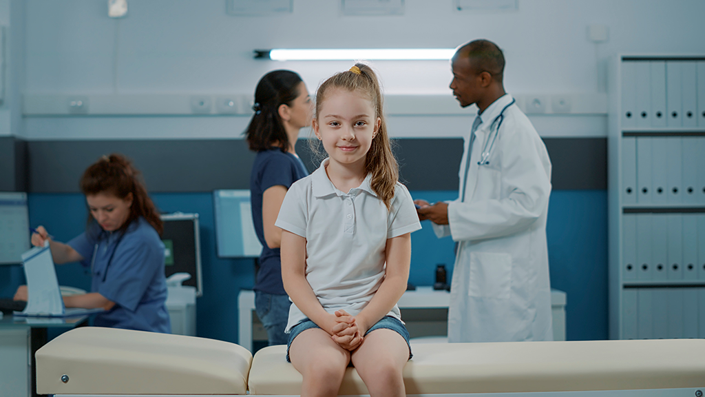 a young patient sitting on a table in a hospital 