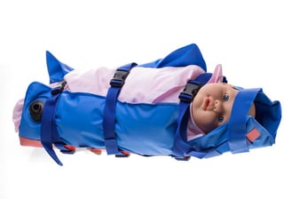 A photo of the Domico Med-Device MedVac Immobilization System with a baby doll inside.